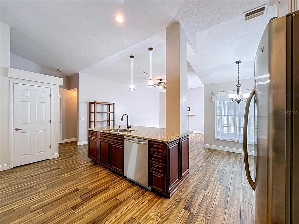 18812 Bascomb Lane Hudson, FL 34667 - Photo 30 of 57 a large kitchen with wooden floor and stainless steel appliances
