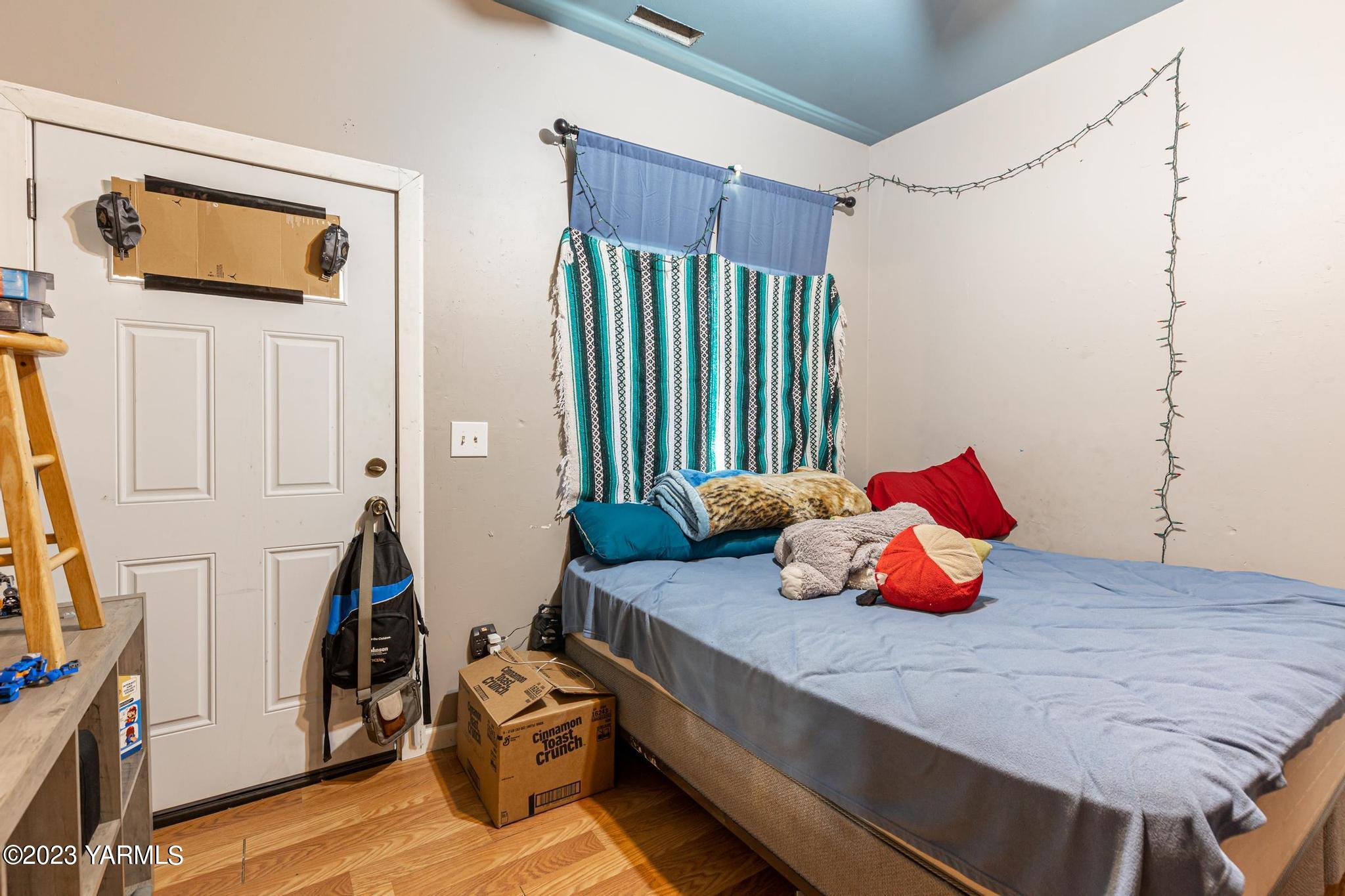 131 Ogle Road Grandview, WA 98930 - Photo 7 of 41 a bedroom with bed and wooden floor