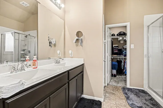 a en suite bathroom with a granite countertop sink and a mirror