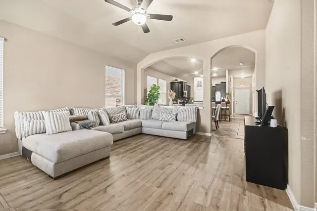 a living room with furniture and wooden floor