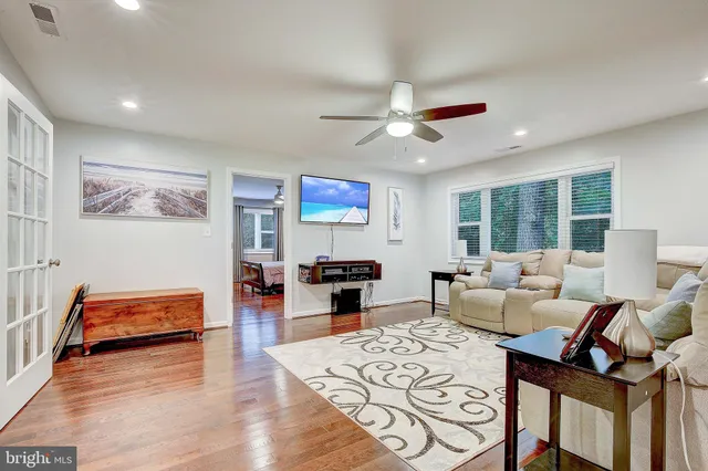 a living room with furniture flat screen tv and a large window