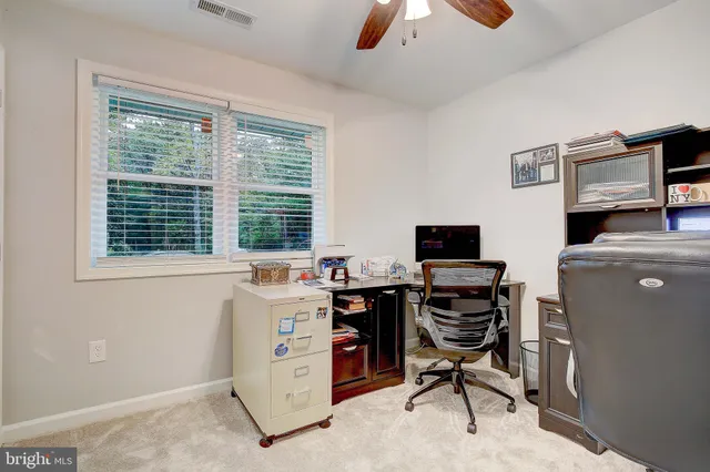 a view of a workspace with furniture and a window