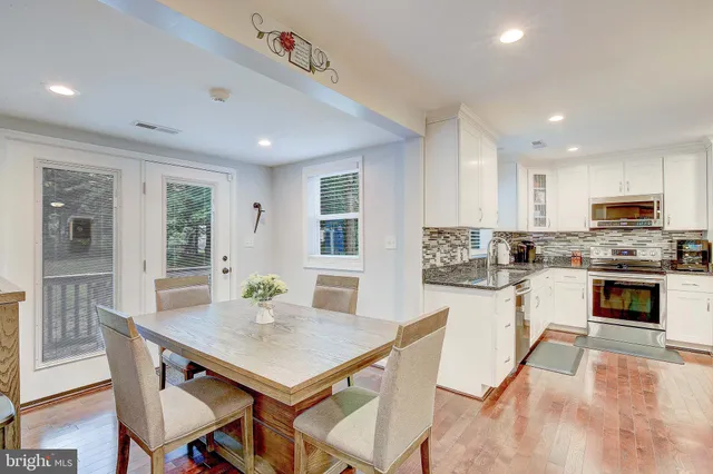 a kitchen with a stove a microwave a dining table and chairs