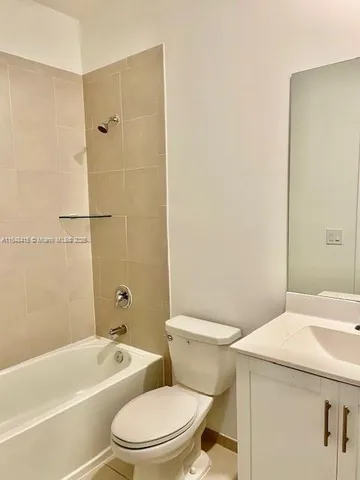 a white toilet and tub sitting next to a bathroom sink