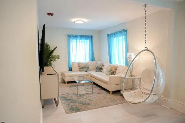 a living room with furniture a window and a flat screen tv