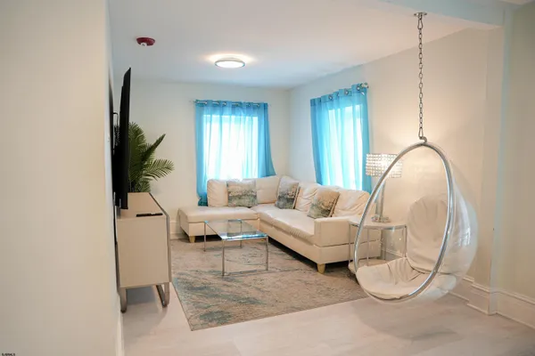 a living room with furniture a window and a flat screen tv