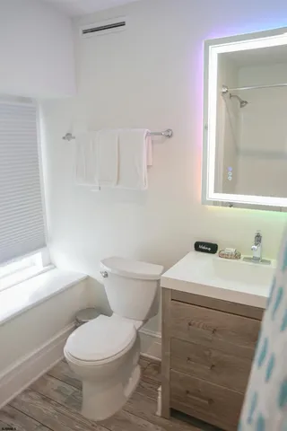 a bathroom with a toilet a sink a vanity and mirror