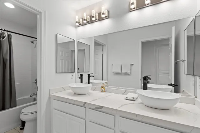 a bathroom with a double vanity sink toilet and a mirror