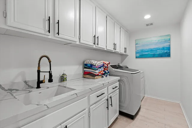 a kitchen with white cabinets and sink