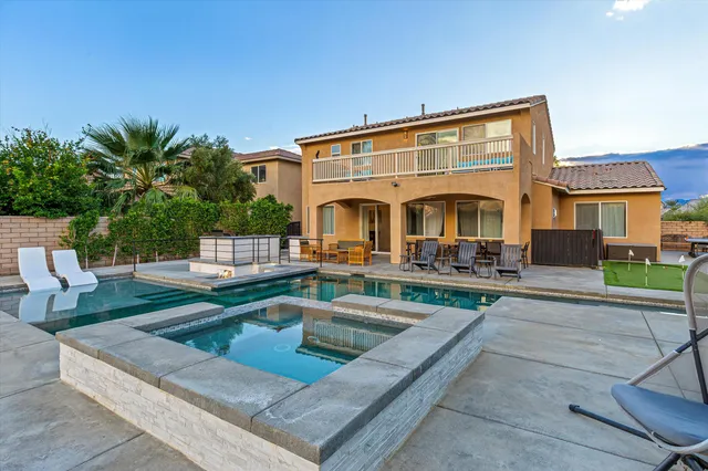 a front view of a house with swimming pool having outdoor seating