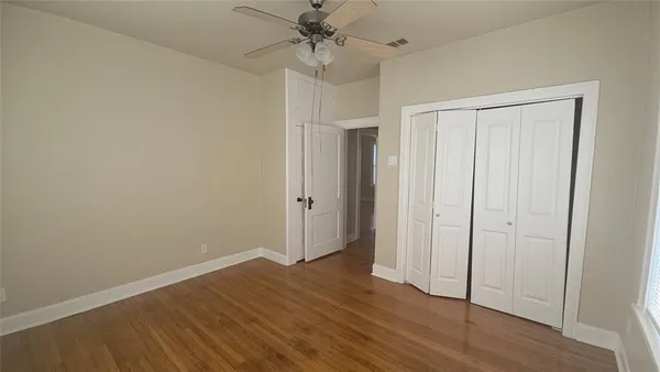 a view of an empty room with wooden floor