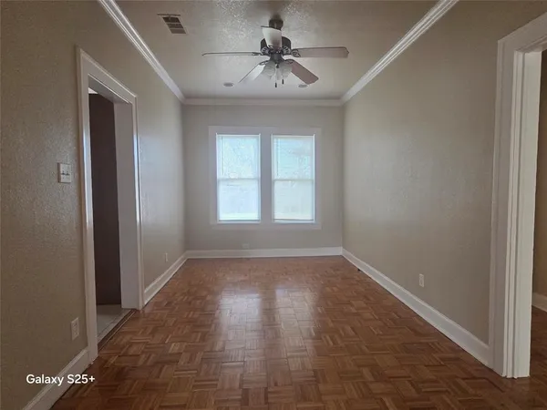 a view of empty room with window and a ceiling fan