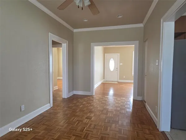 a view of a hallway with wooden floor and a bathroom
