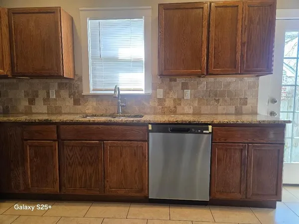 a kitchen with granite countertop cabinets and window
