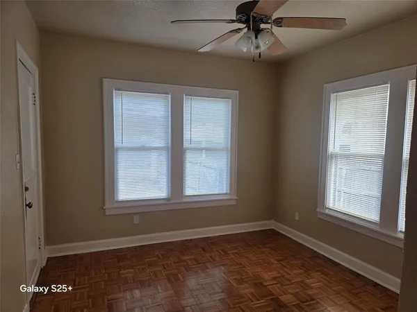 an empty room with a window and a ceiling fan