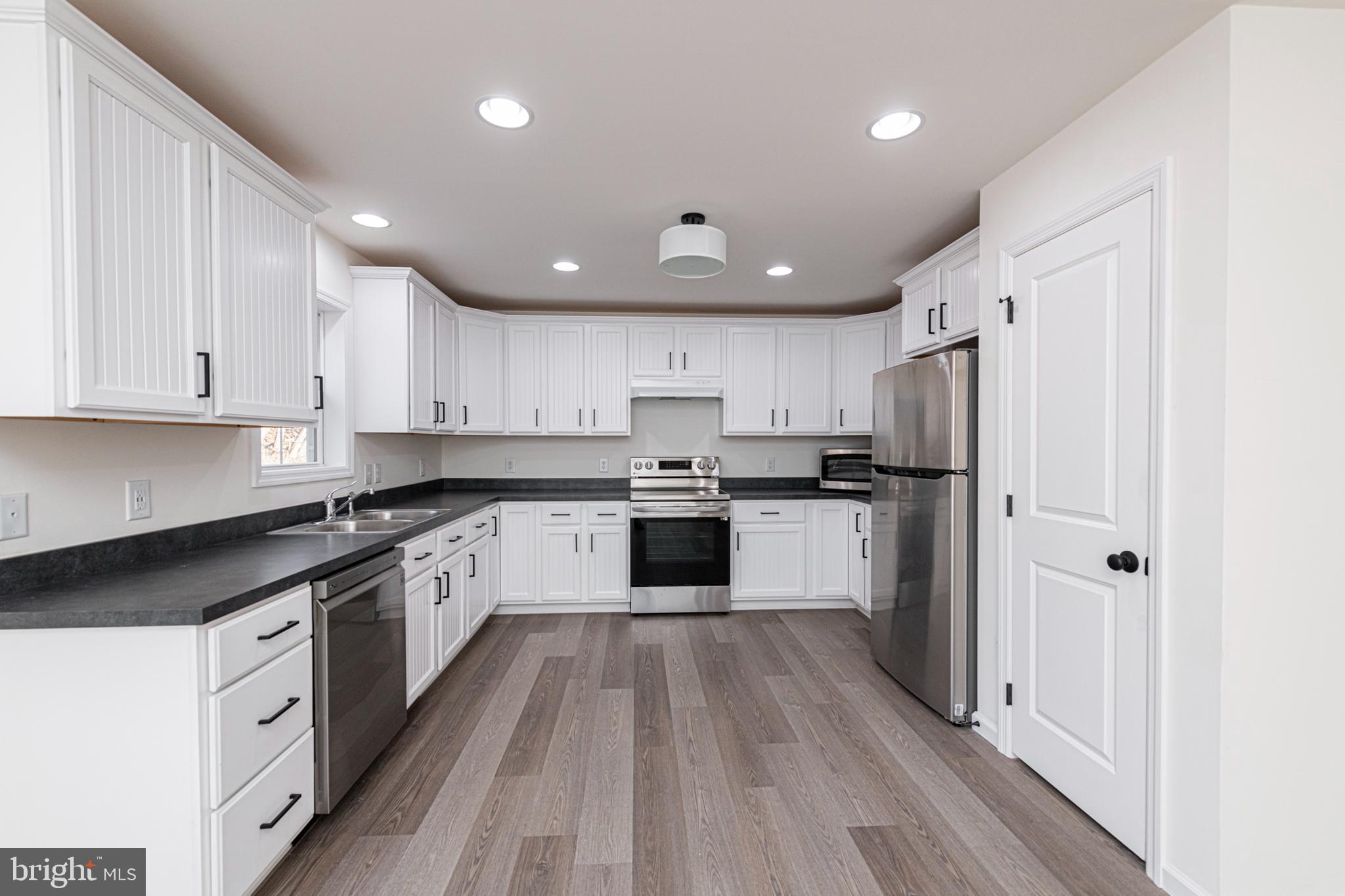 617 Port Providence Road Phoenixville, PA 19460 - Photo 7 of 25 a kitchen with a refrigerator a sink and dishwasher with wooden floors
