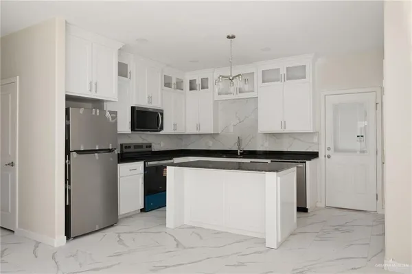 a kitchen with stainless steel appliances granite countertop a stove and a refrigerator