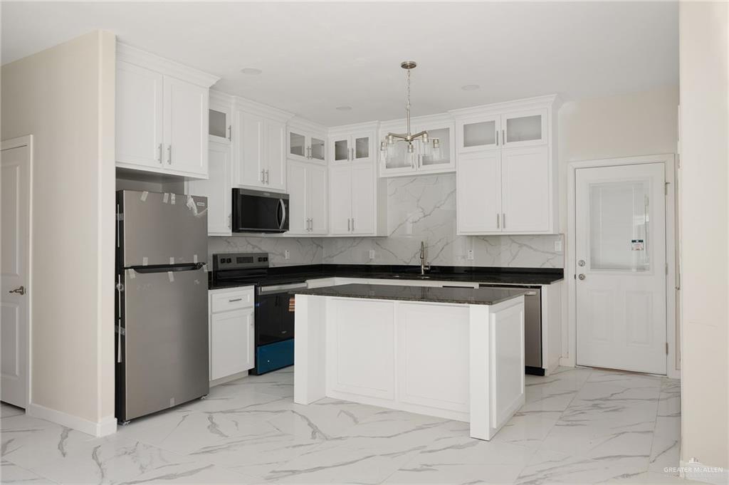 602 Mountain Road, Unit 12B Mission, TX 78573 - Photo 3 of 10 a kitchen with stainless steel appliances granite countertop a stove and a refrigerator