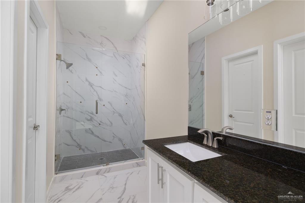 602 Mountain Road, Unit 12B Mission, TX 78573 - Photo 7 of 10 a bathroom with a granite countertop sink and a mirror