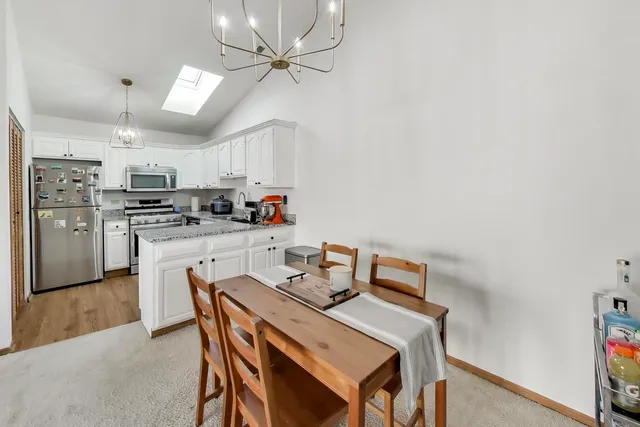 a kitchen with kitchen island a stove a table and chairs in it