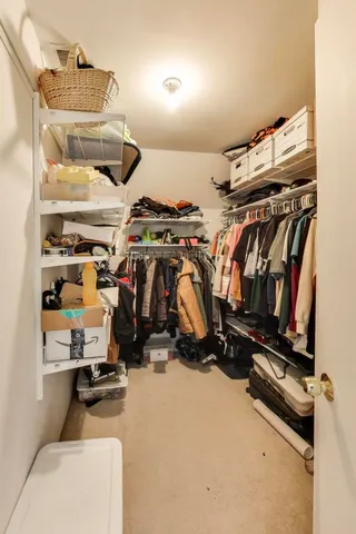 a view of walk in closet with clothes and shoes