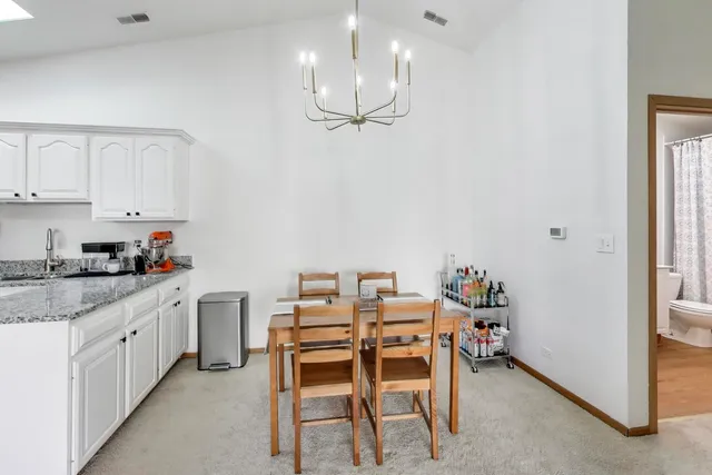 a kitchen with a dining table chairs and cabinets