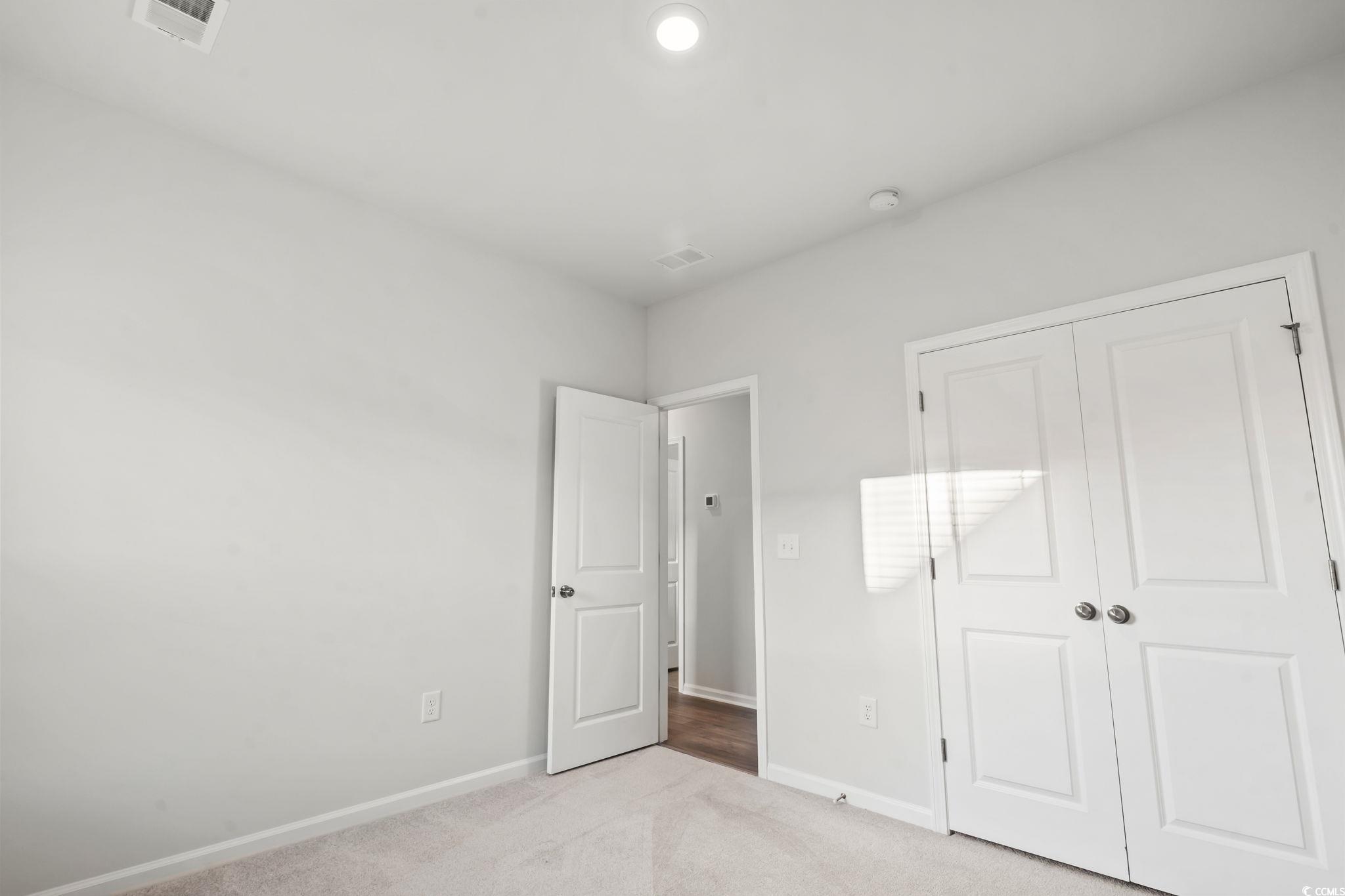 229 Cypress Tree Loop Longs, SC 29568 - Photo 10 of 40 Unfurnished bedroom featuring light carpet and a c