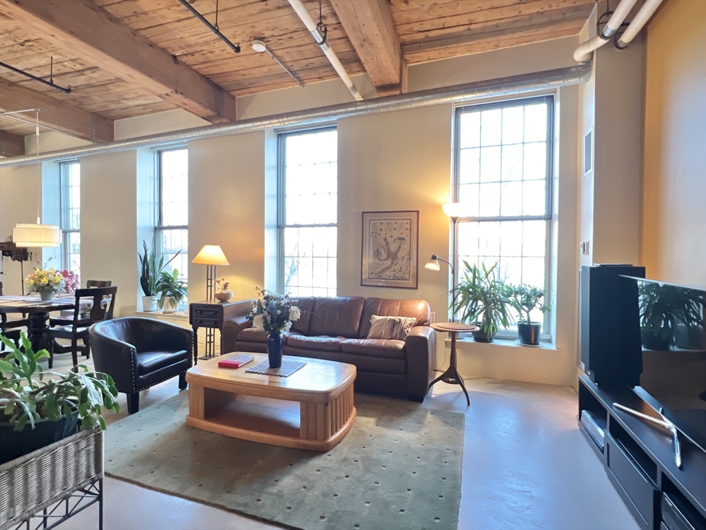 a living room with fireplace furniture and a large window