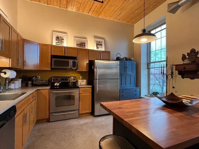 a kitchen with stainless steel appliances granite countertop a sink stove and refrigerator