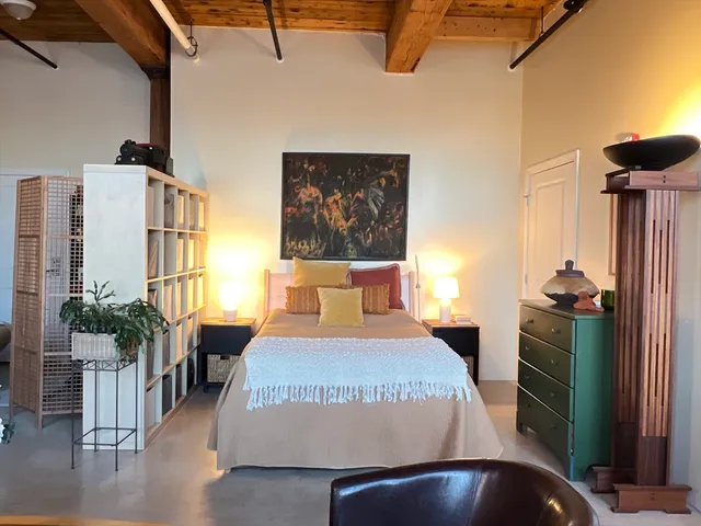 a bedroom with a bed and a potted plant