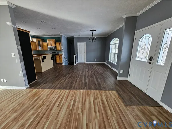a kitchen with stainless steel appliances granite countertop a refrigerator a sink dishwasher a stove and white countertops with wooden floor