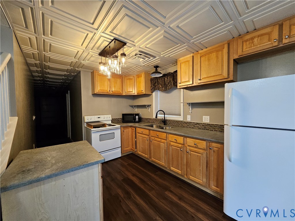 5195 Lennie Road McKenney, VA 23872 - Photo 30 of 45 a kitchen with stainless steel appliances granite countertop a refrigerator a sink dishwasher a stove and white countertops with wooden floor