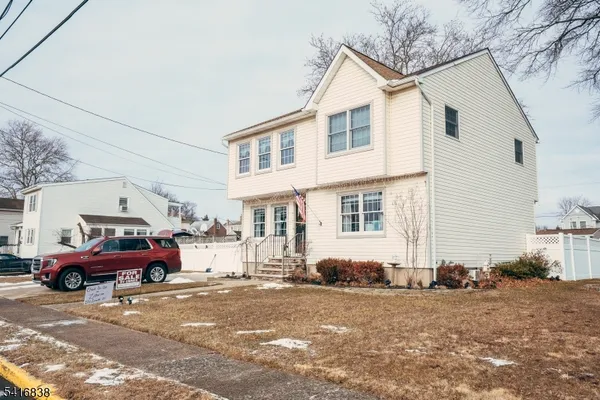 a front view of a house with cars parked