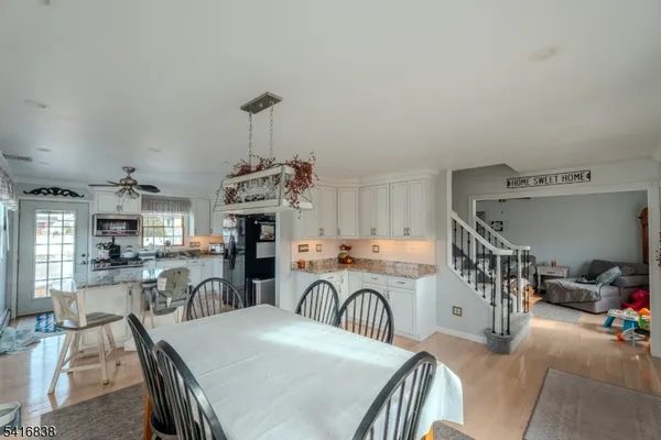 a kitchen with stainless steel appliances granite countertop a dining table and chairs