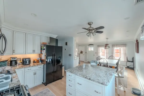 a kitchen with a refrigerator sink and white cabinets