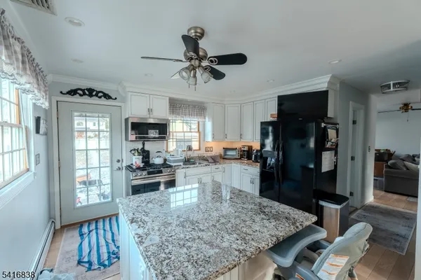 a kitchen with stainless steel appliances granite countertop sink stove refrigerator and cabinets