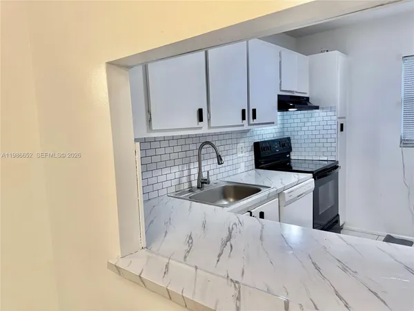 a kitchen with stainless steel appliances a sink a stove and cabinets