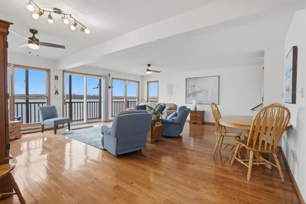 a living room with furniture kitchen view and a wooden floor