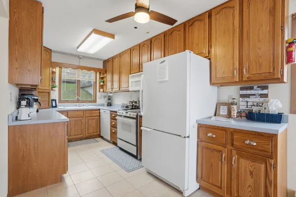 a kitchen with a refrigerator a stove a sink dishwasher and cabinets