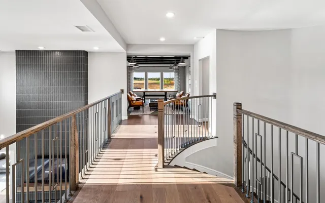 a view of a hallway with wooden floor and dining room