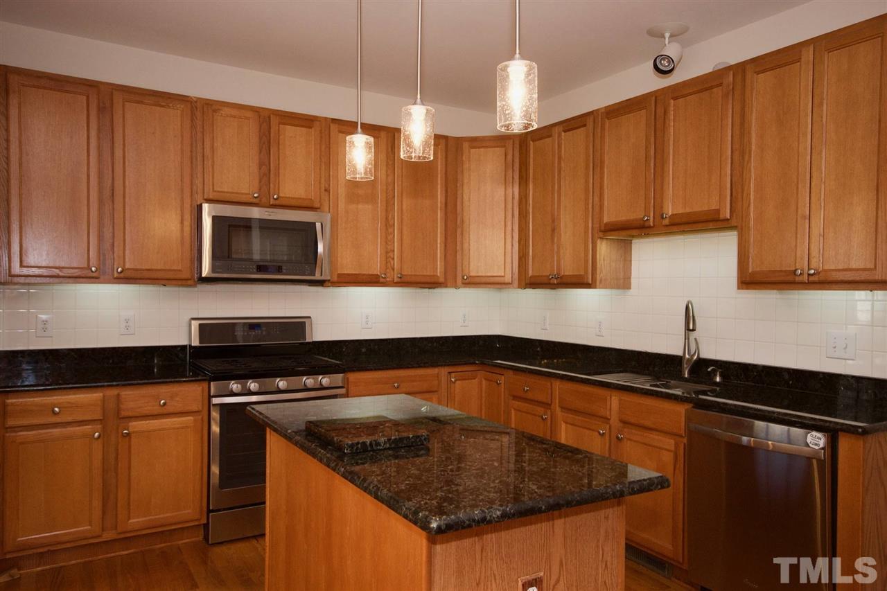 157 Mickleson Ridge Drive Raleigh, NC 27603 - Photo 13 of 30 a kitchen with granite countertop a sink a stove and cabinets