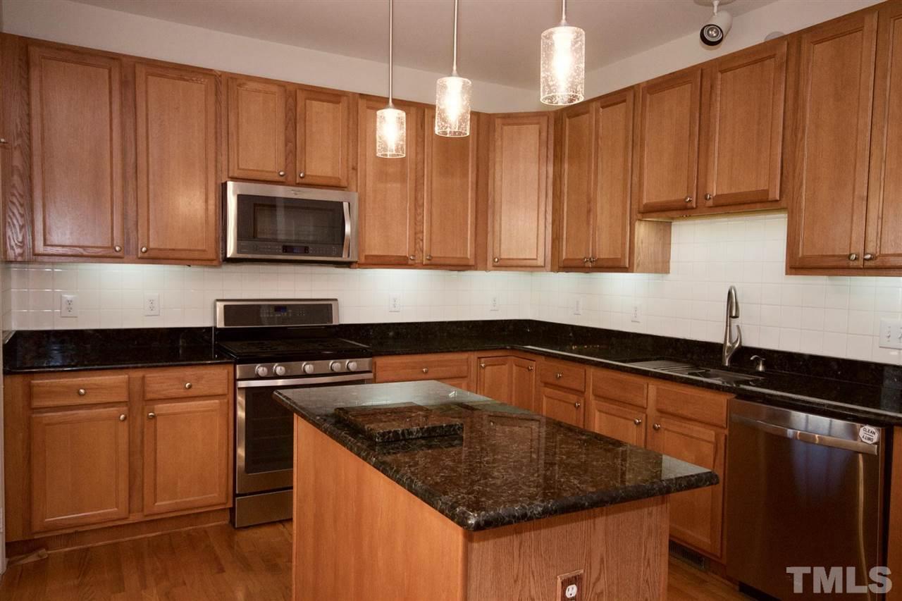 157 Mickleson Ridge Drive Raleigh, NC 27603 - Photo 16 of 30 a kitchen with granite countertop a sink stove and microwave