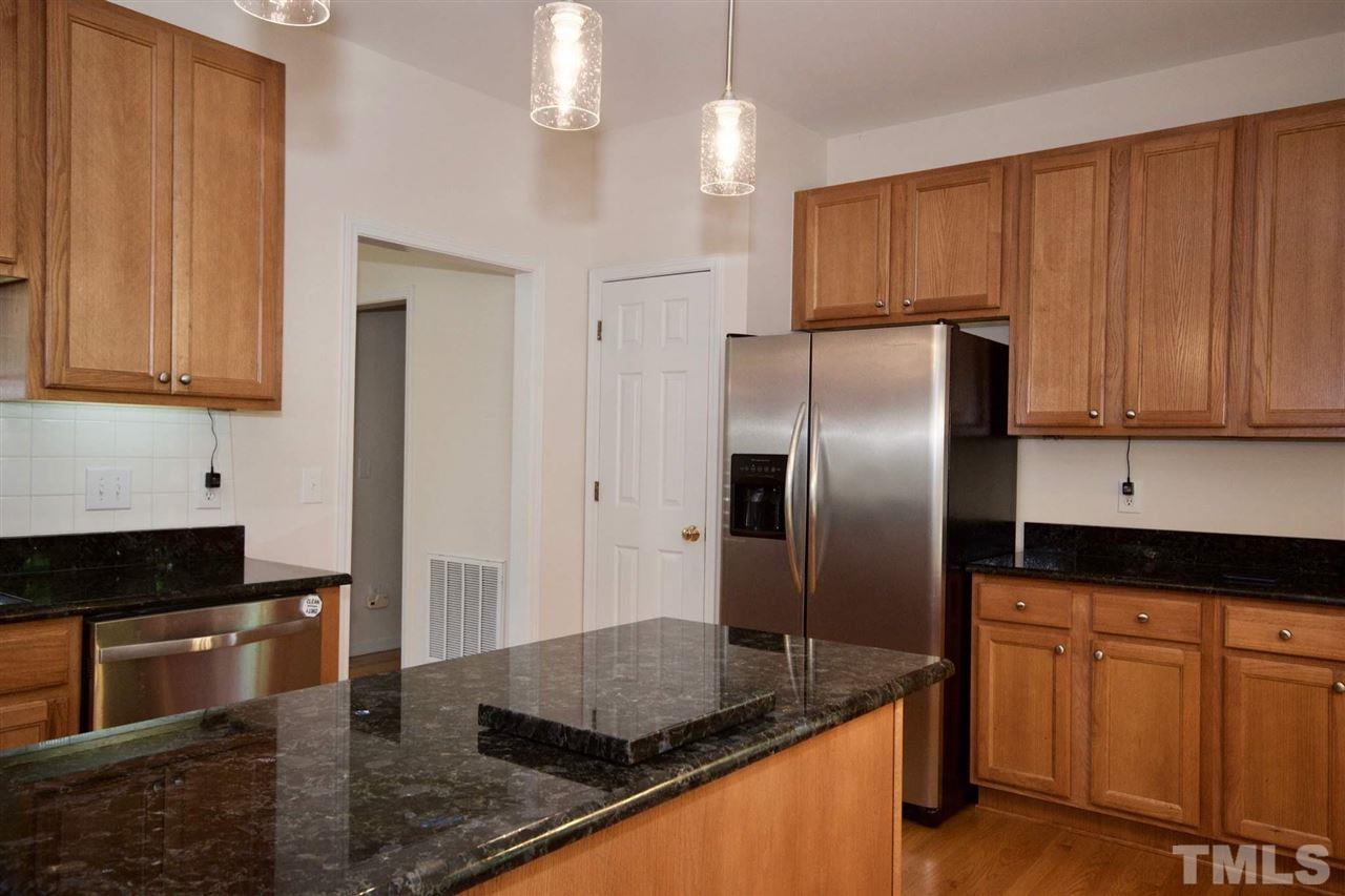 157 Mickleson Ridge Drive Raleigh, NC 27603 - Photo 17 of 30 a kitchen with granite countertop stainless steel appliances a refrigerator a stove a sink and cabinets