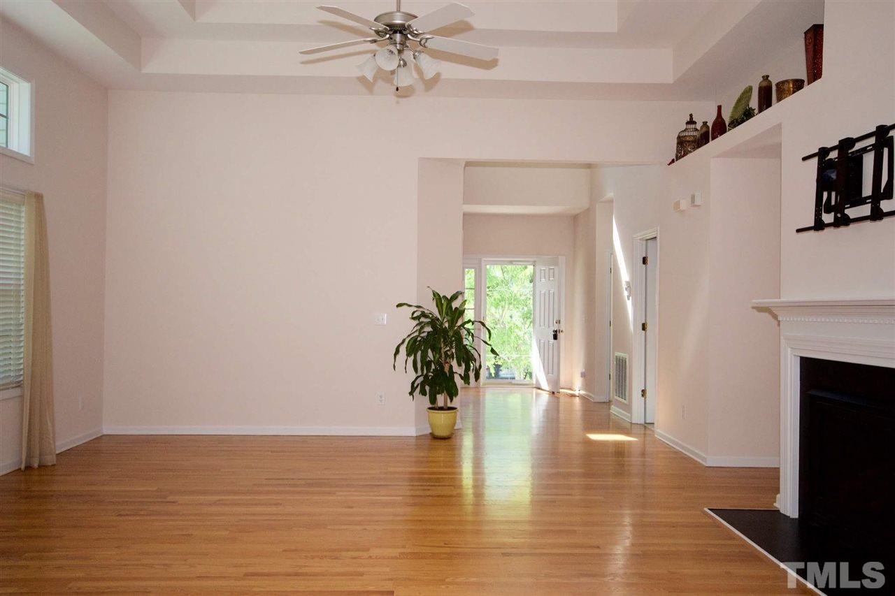 157 Mickleson Ridge Drive Raleigh, NC 27603 - Photo 5 of 30 a view of an empty room and kitchen with fireplace wooden floor and a window