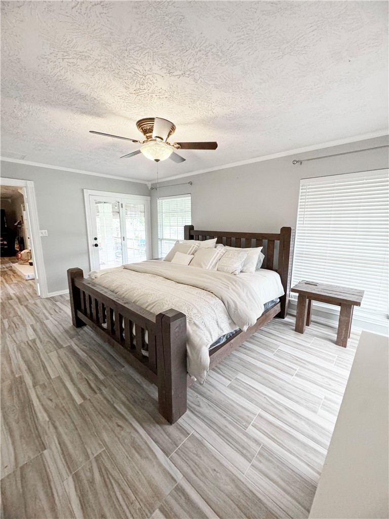 9462 Riley Green Road Franklin, TX 77856 - Photo 19 of 45 a bedroom with a bed and a chandelier