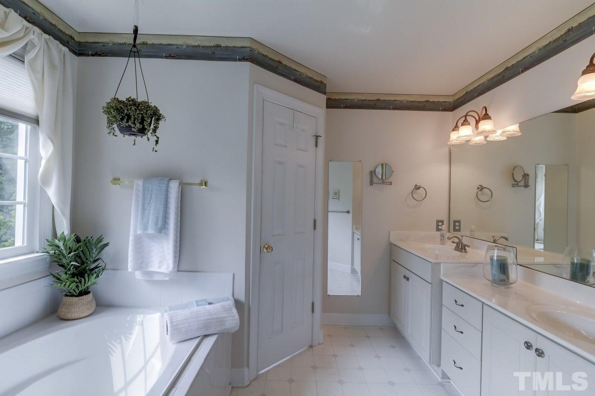 7913 Mayapple Place Raleigh, NC 27613 - Photo 11 of 20 a bathroom with a double vanity sink and shower