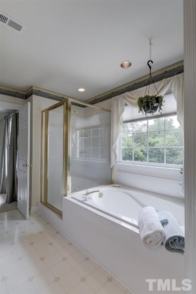7913 Mayapple Place Raleigh, NC 27613 - Photo 12 of 20 a bathroom with a bathtub and a shower