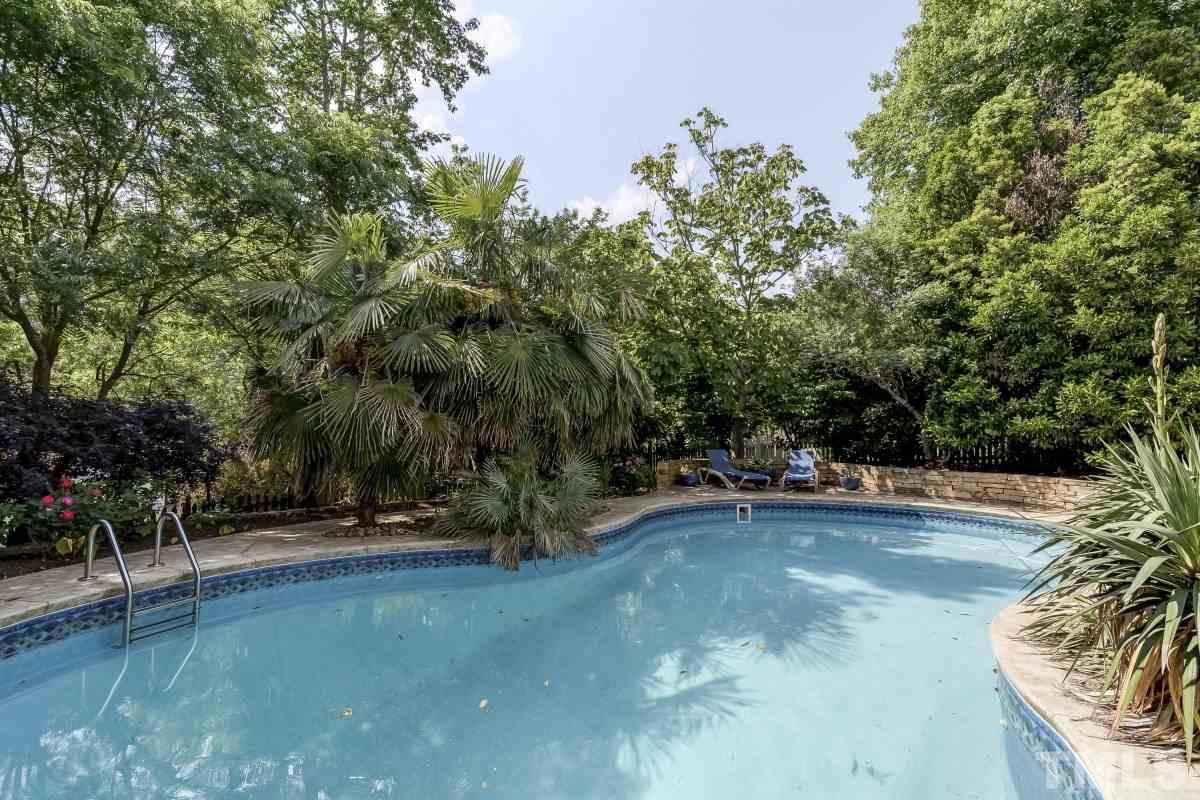 7913 Mayapple Place Raleigh, NC 27613 - Photo 20 of 20 a view of a swimming pool with lawn chairs under an umbrella