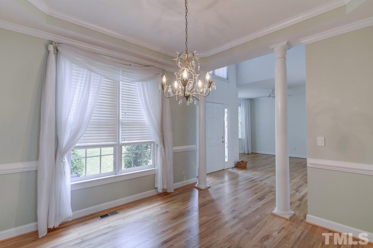 7913 Mayapple Place Raleigh, NC 27613 - Photo 3 of 20 a view of a livingroom with a chandelier wooden floor and windows