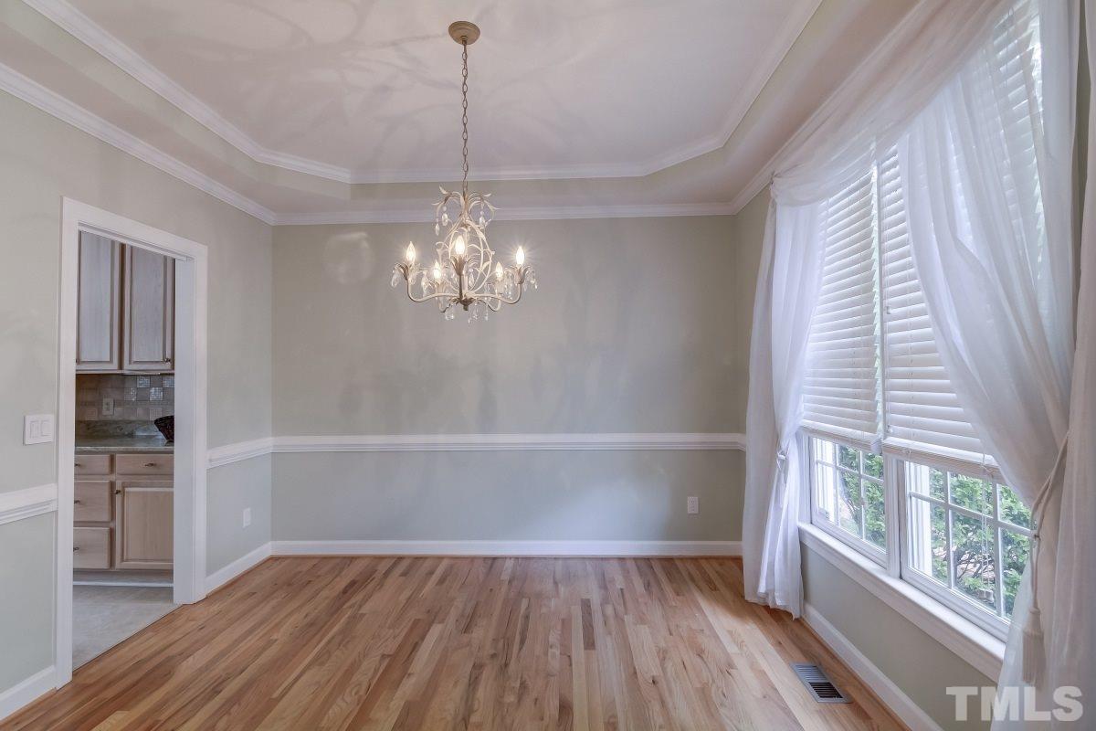 7913 Mayapple Place Raleigh, NC 27613 - Photo 4 of 20 a view of empty room with wooden floor and fan